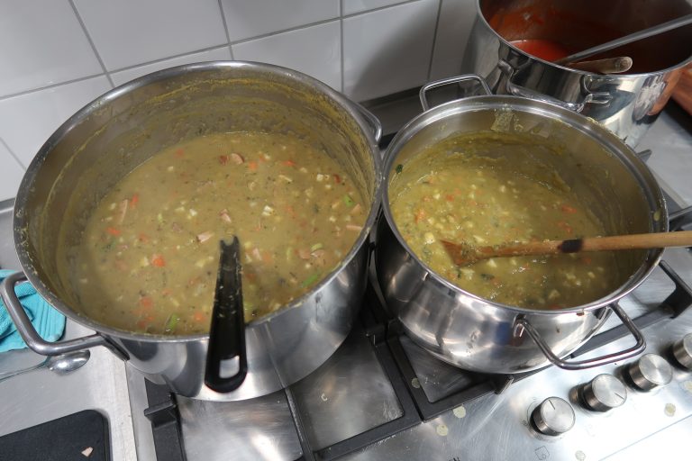 Grote pannen snert staan in de keuken.