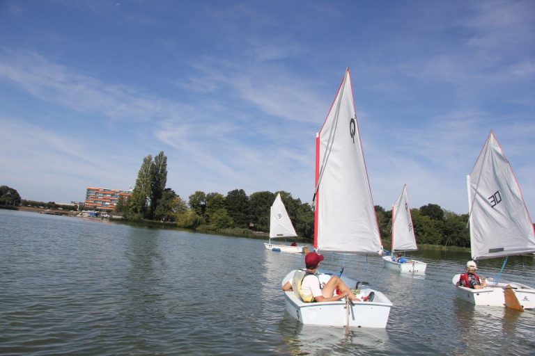 Meerdere Optimist zeilboten varen samen op de Oosterplas.