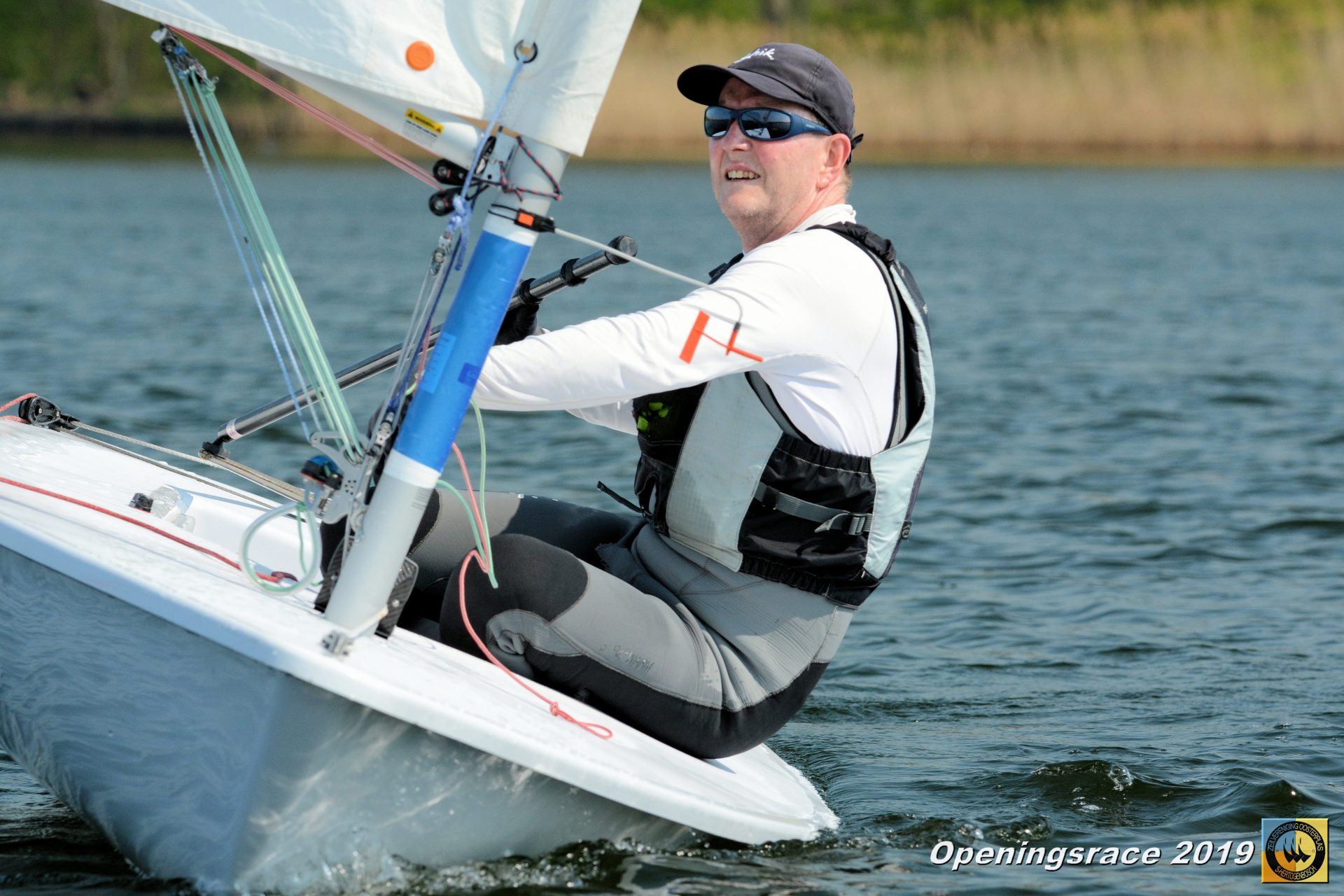 Een glimlachende zeiler zit in een Laser zwaardboot tijdens de Openingsrace ZVO 2019.