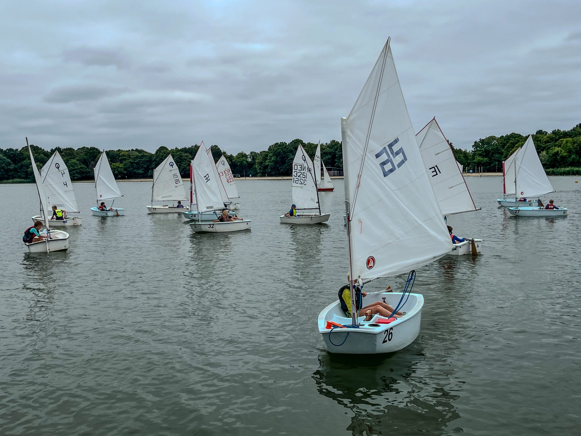Optimist zeilboten varen richting de kant of steiger.