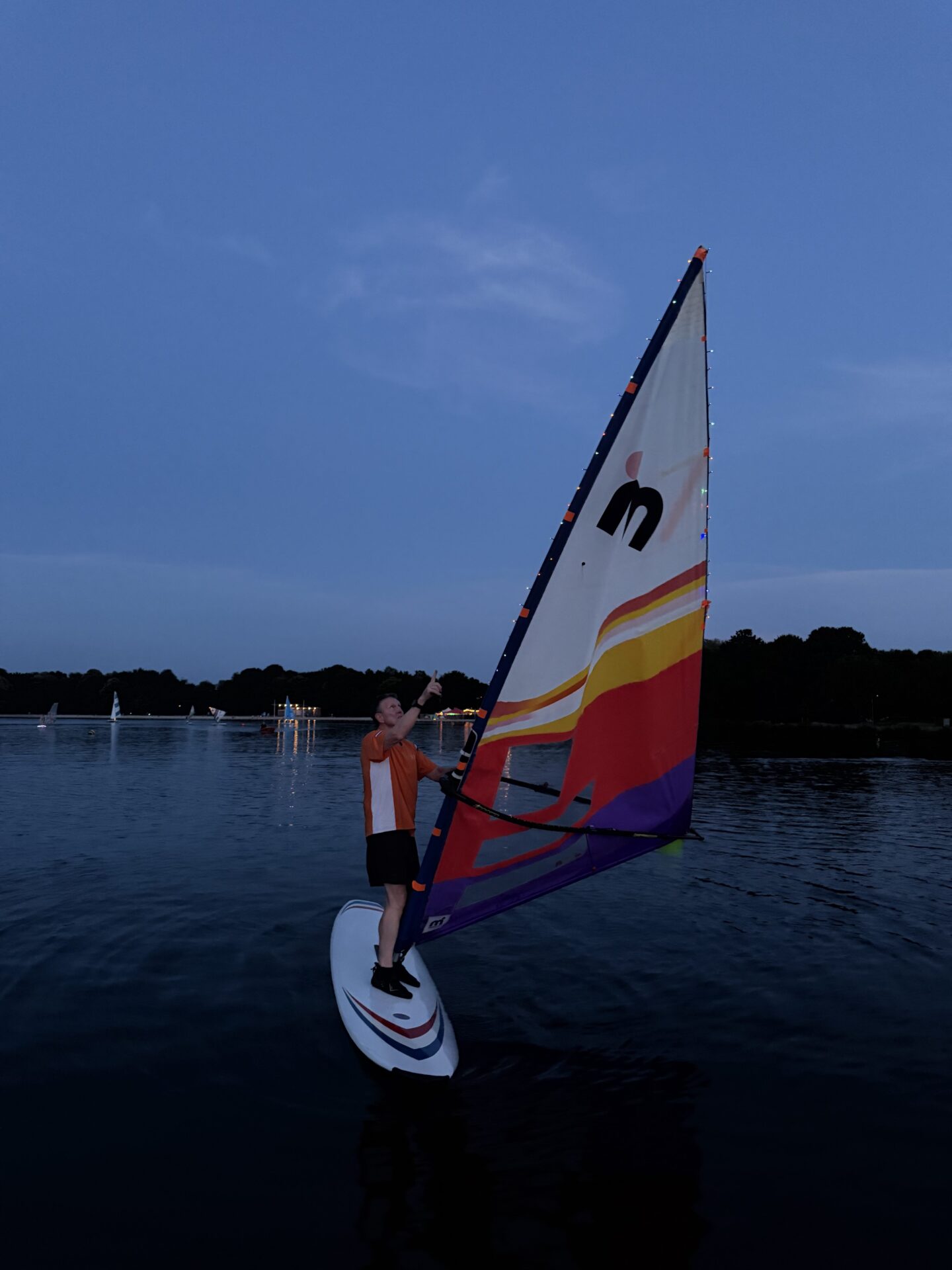 Een windsurfer vaart in de schemering op de Oosterplas tijdens Midzomernacht 2026.