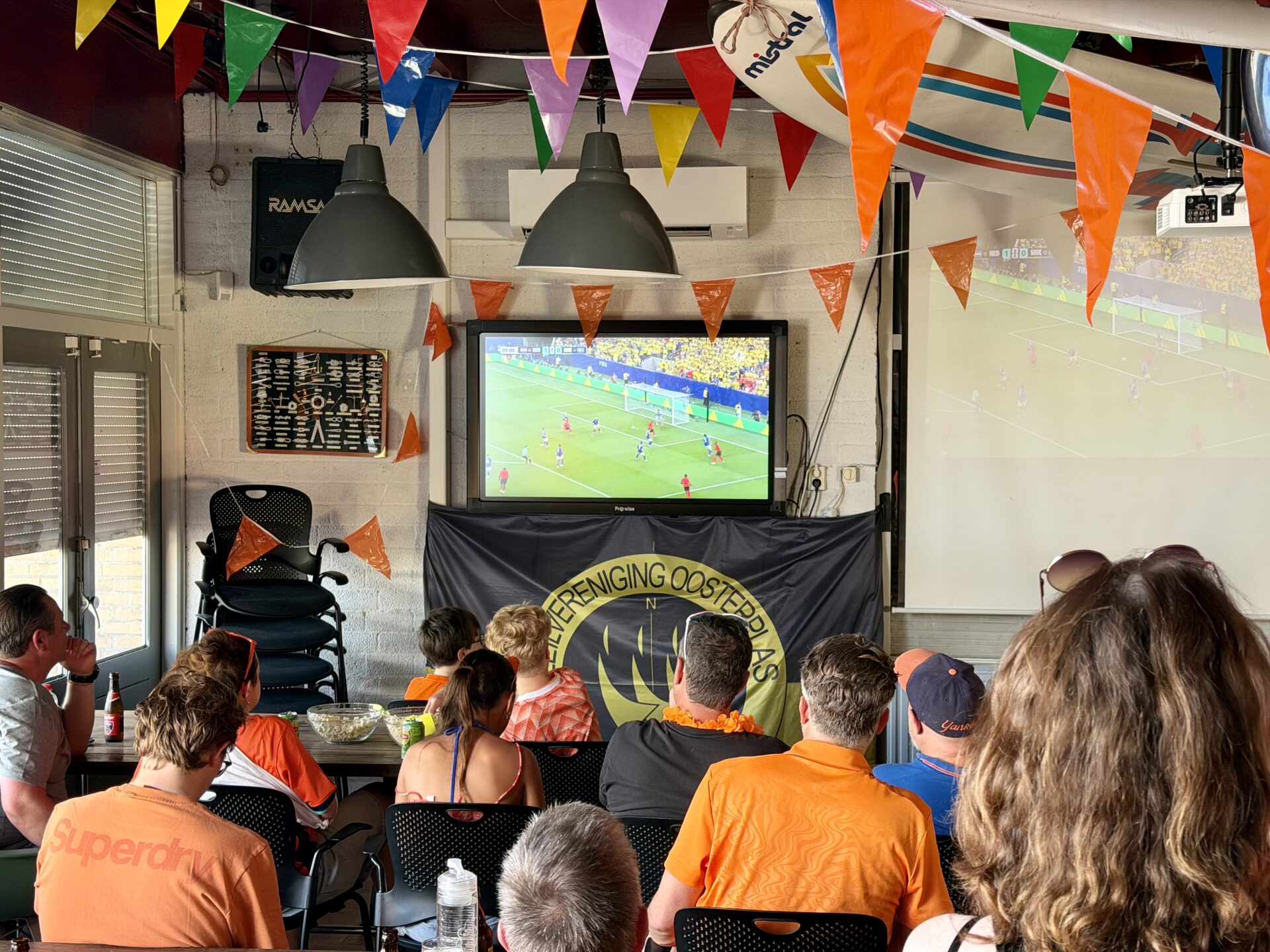 Deelnemers kijken in het clubhuis naar voetbal tijdens Midzomernacht 2026.